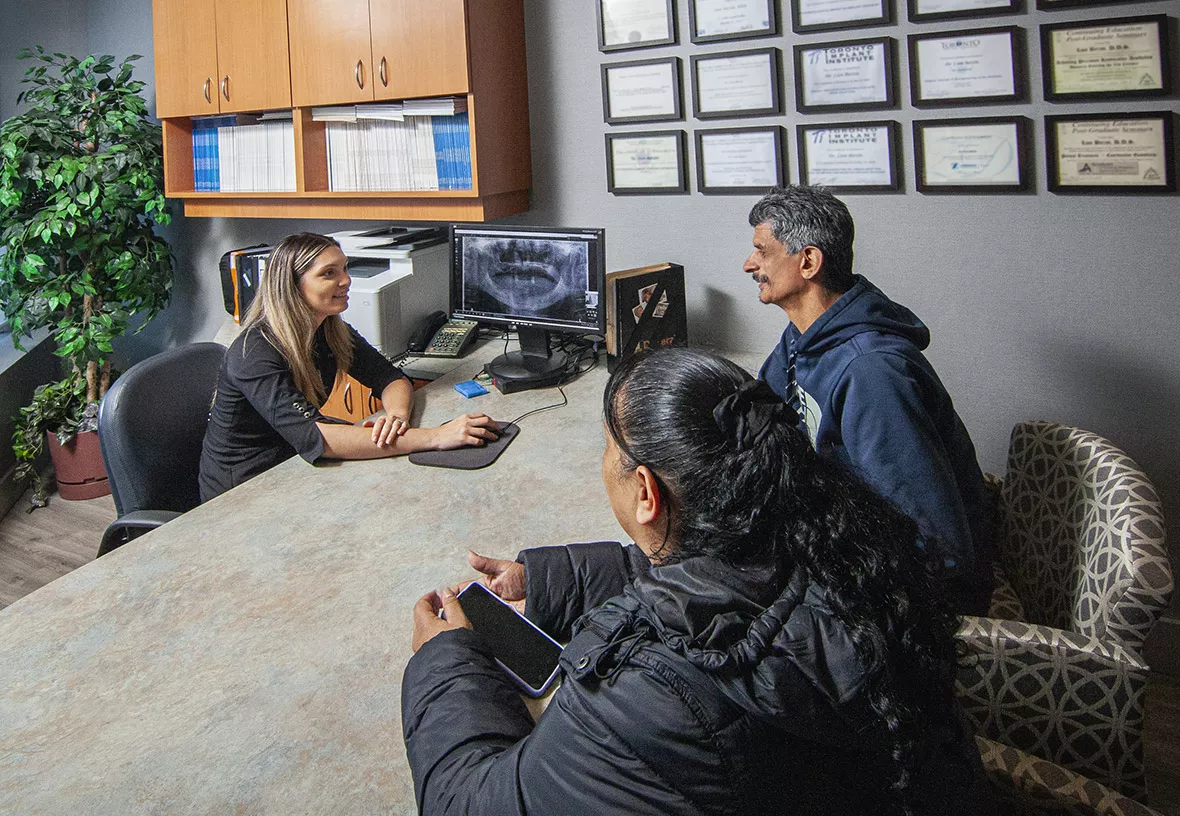 Dental implants consultation with smiling patient and his spouse